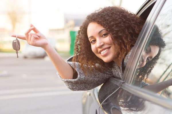 woman in new car holding out keys